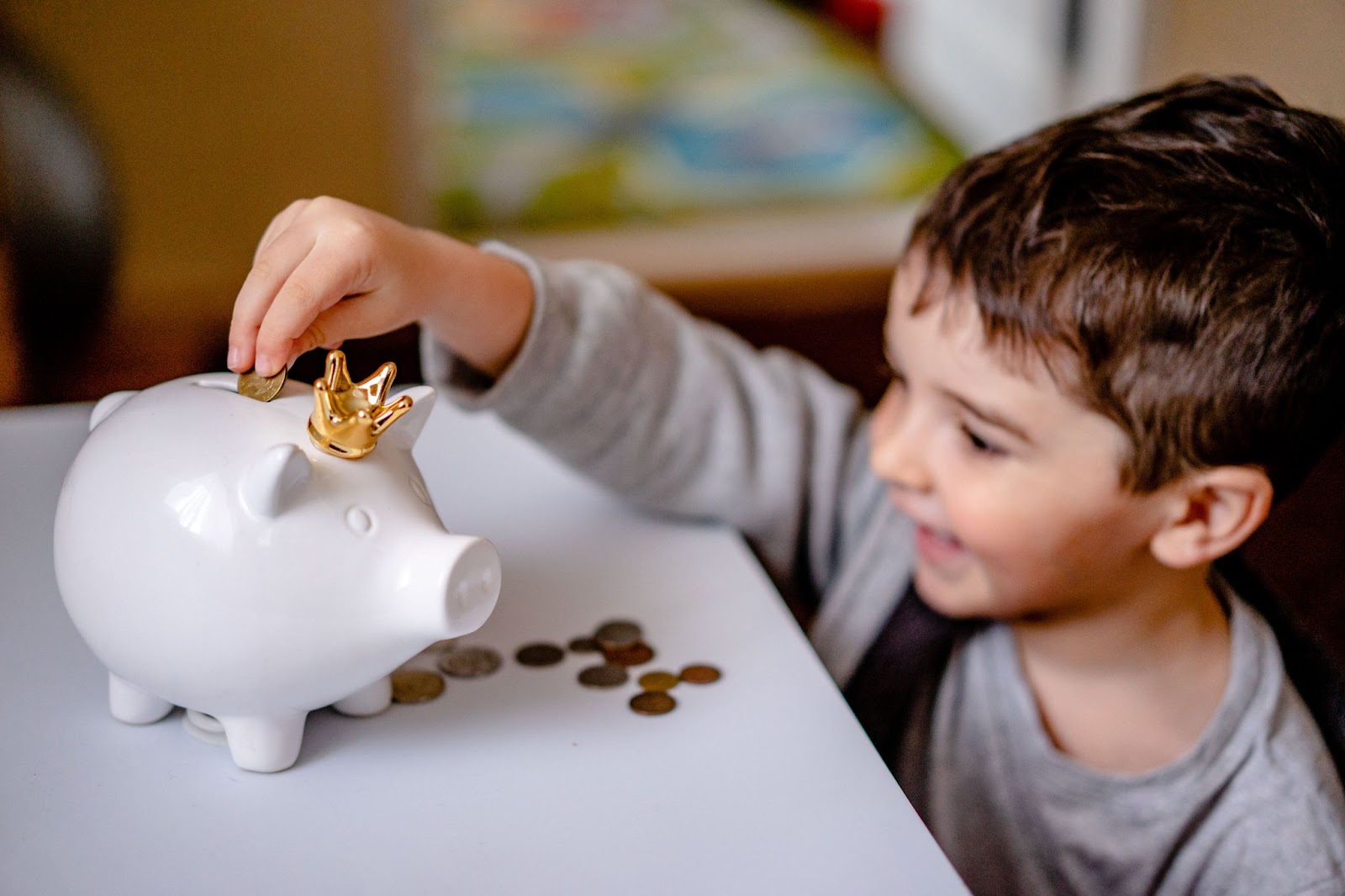 a kid placing a coin into a white piggy bank